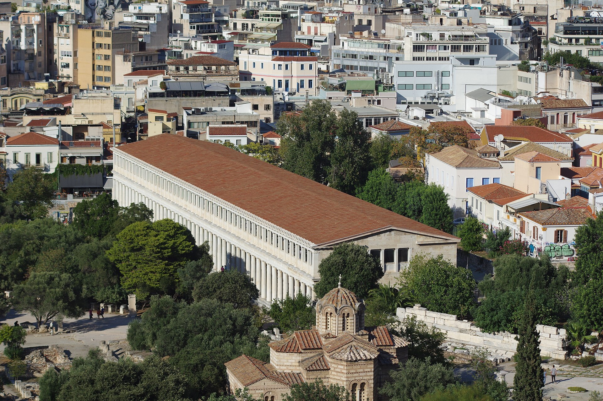The rebuilt Stoa of Attalos seen from above, with its 2 storeys of white colonnade and red tiled roof; in front, the dome of the church of the Holy Apostles