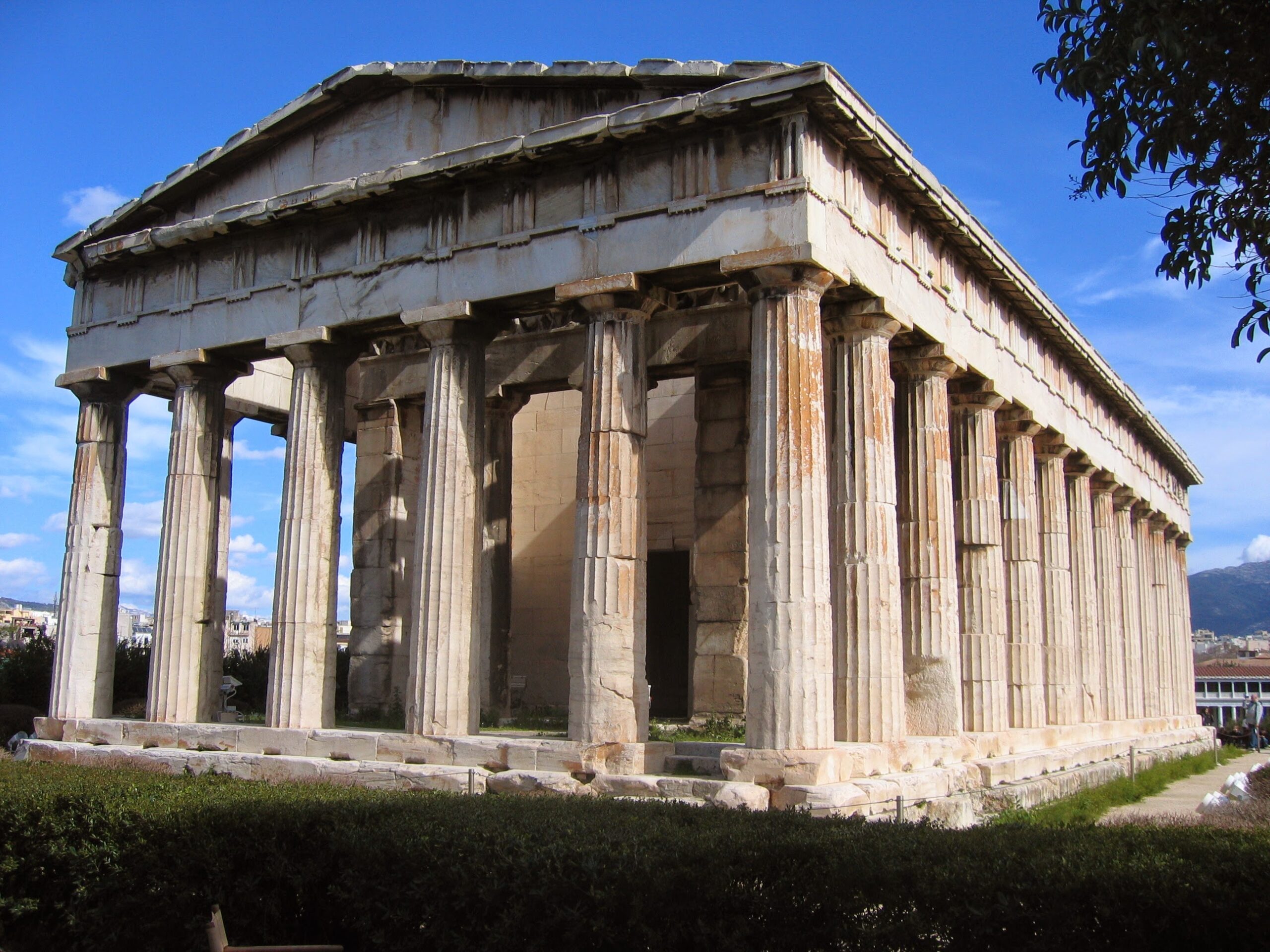 The Temple of Hephaestus in Athens seen from the corner, with the Doric columns of the front and the flank, the sculpted frieze and the roof still in place