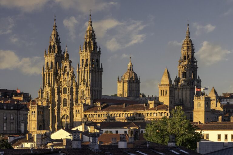 Santiago de Compostela Cathedral seen from Alameda Park in the evening light: the baroque Obradoiro towers and the dome rising above the old town roofs