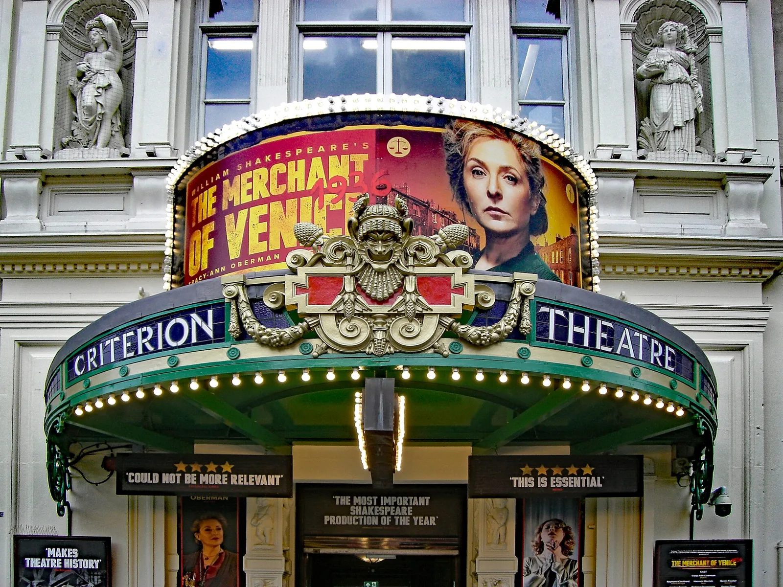 Green entrance canopy of the Criterion Theatre with its name in letters and the poster of the current show above