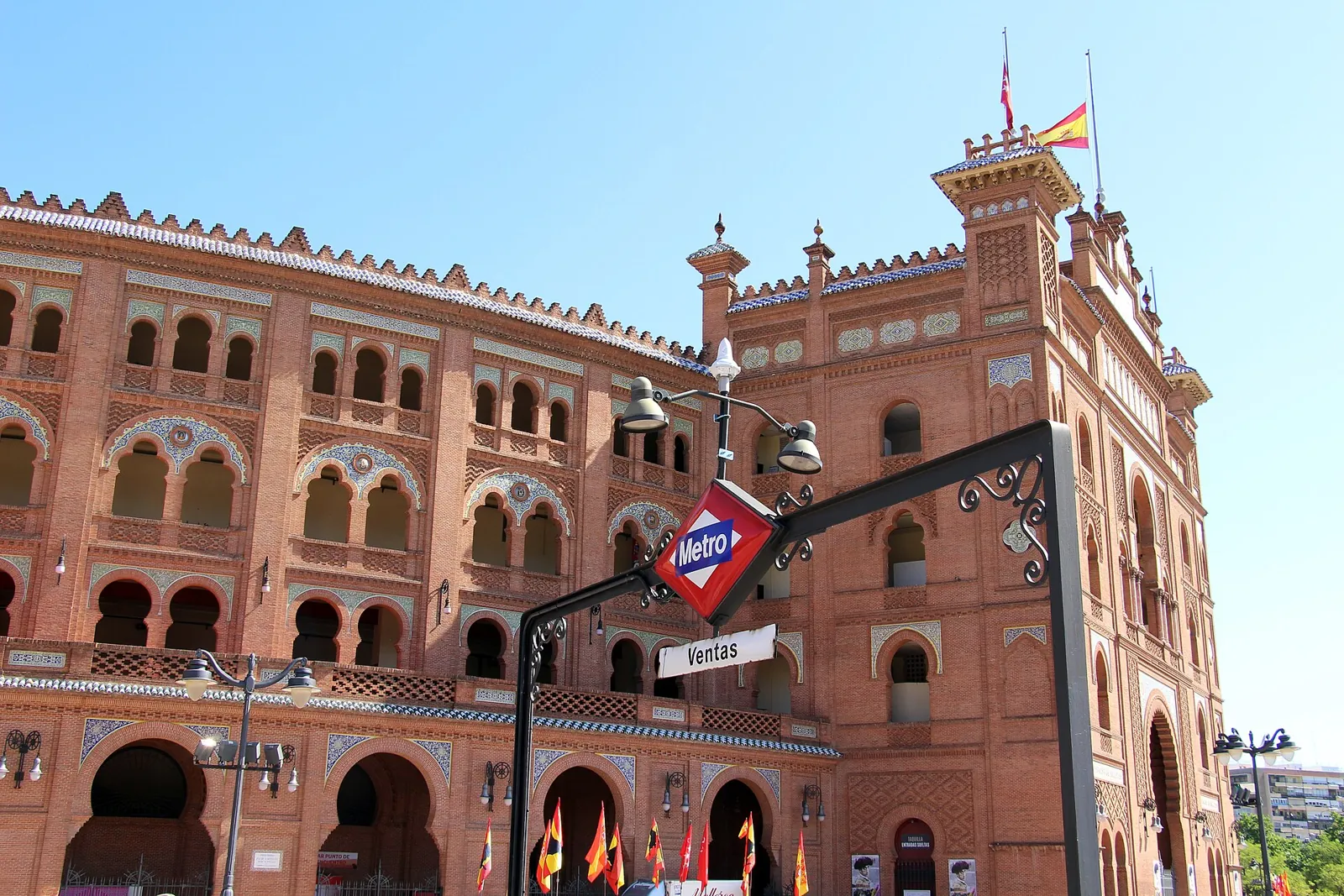 Ventas metro station entrance with its red and blue sign in front of the bullring facade