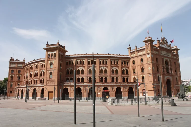 Neo-Mudéjar facade of Las Ventas bullring in Madrid, red brick with horseshoe arches, corner towers and an open square in front