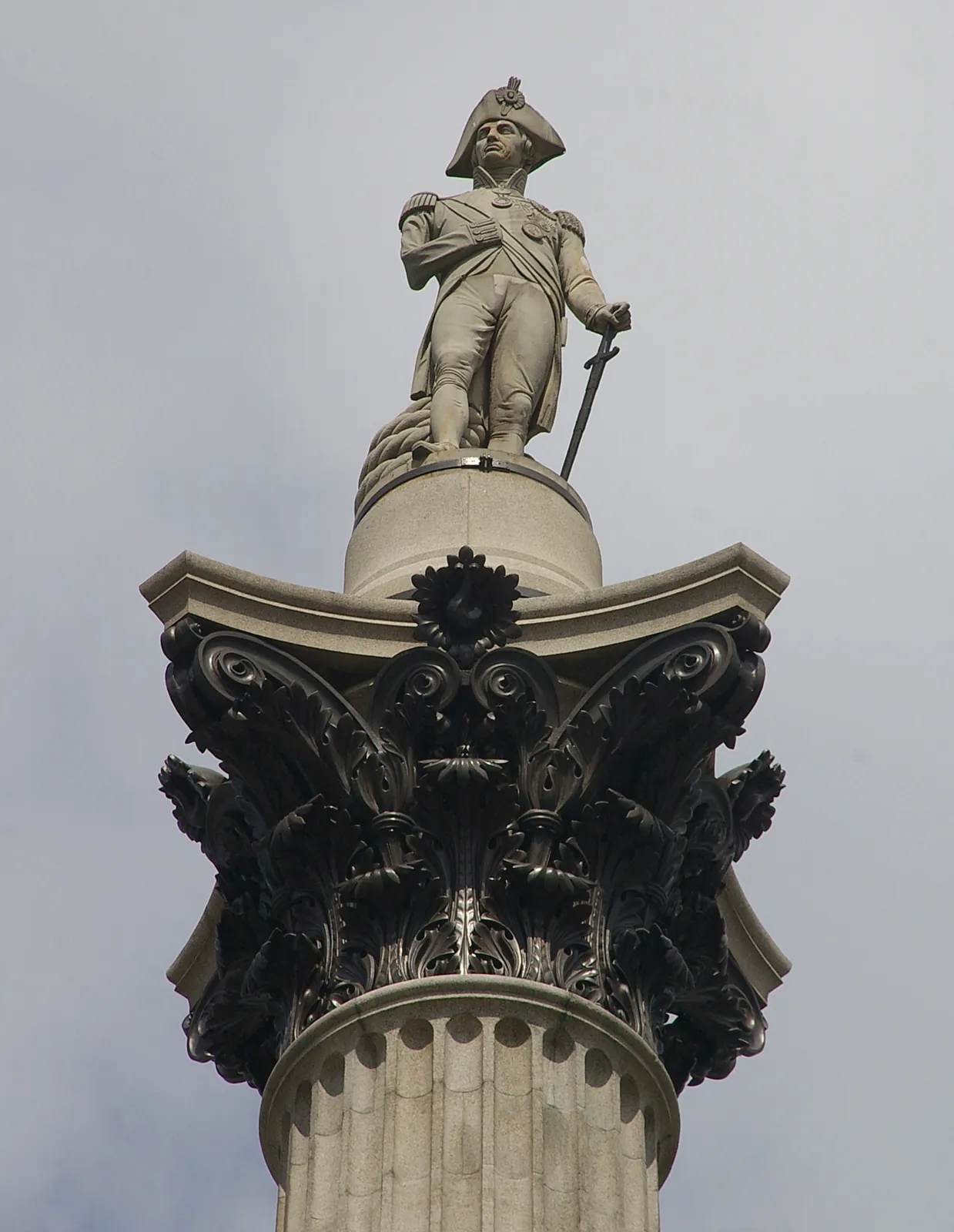 The stone statue of Nelson, in his bicorne hat, on the bronze Corinthian capital of the column