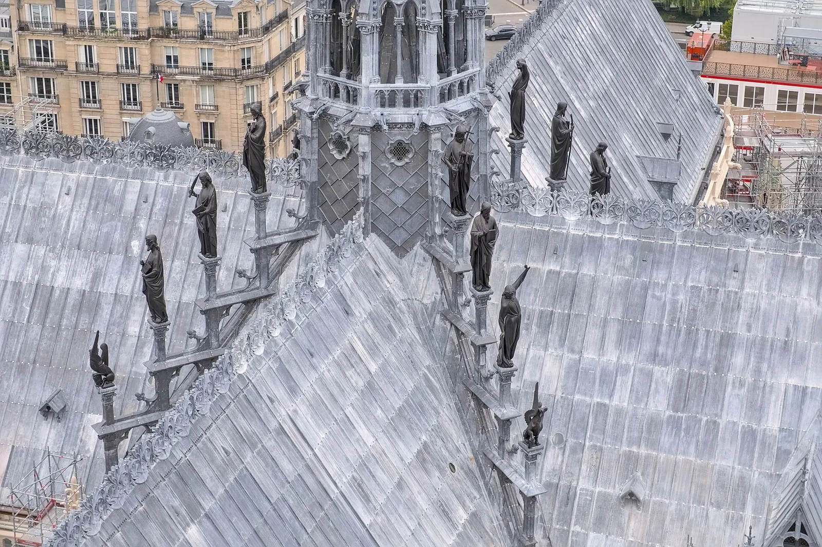 Copper statues of apostles stepping down the lead roof towards the base of the spire, seen from the top of the south tower