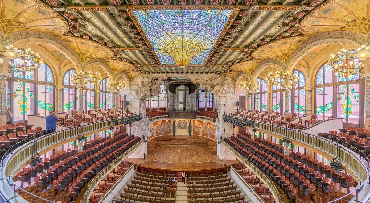 The concert hall of the Palau de la Música Catalana seen from the upper balcony, with the stalls, the stage, the organ and the skylight above