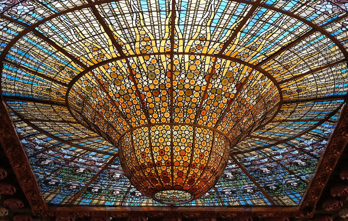 The stained-glass skylight in the ceiling of the Palau de la Música Catalana concert hall, an inverted dome of gold glass framed by blue panes