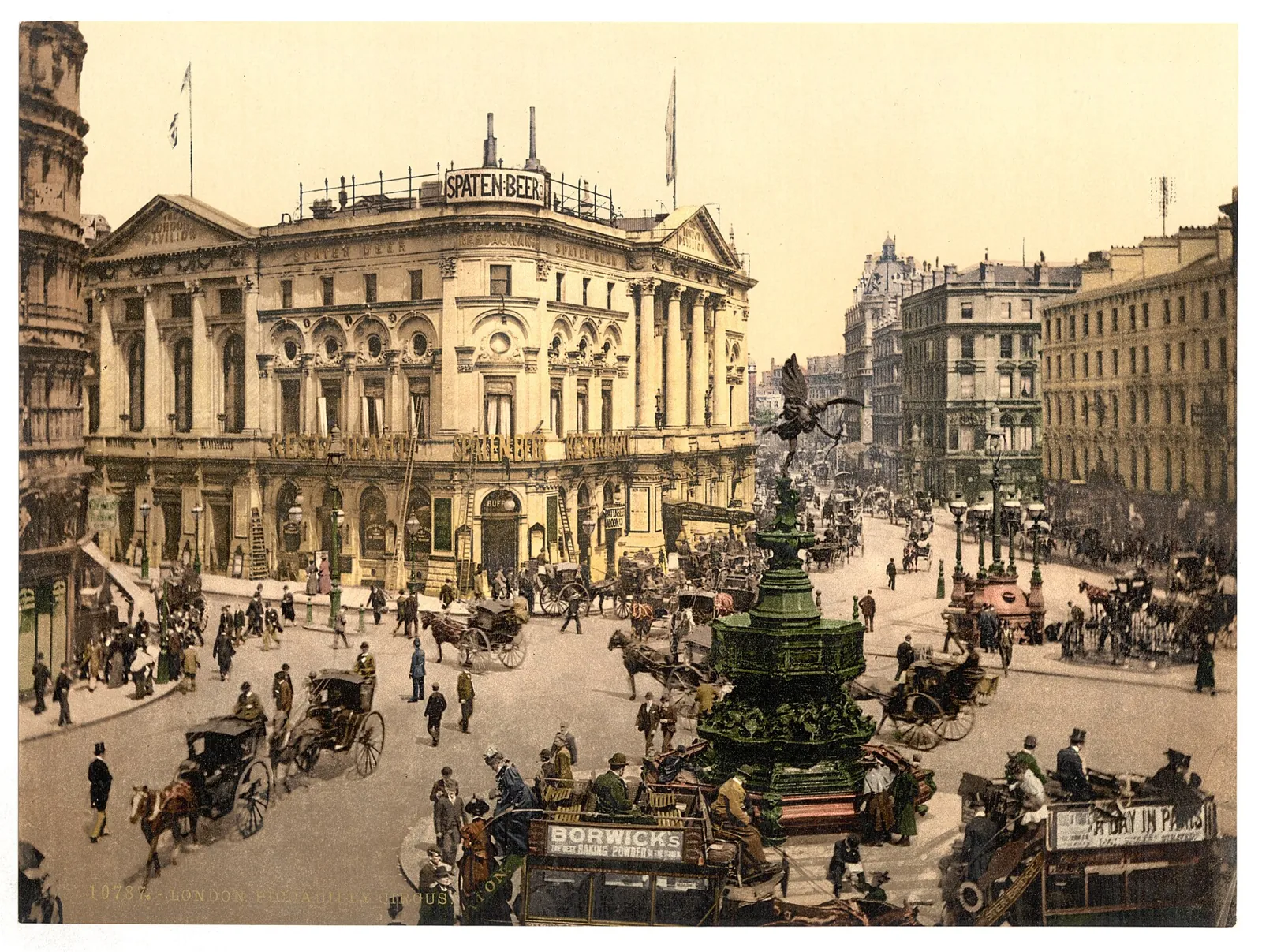 Coloured photochrom of Piccadilly Circus in the 1890s, with the fountain in the middle and horse-drawn carriages and omnibuses around it