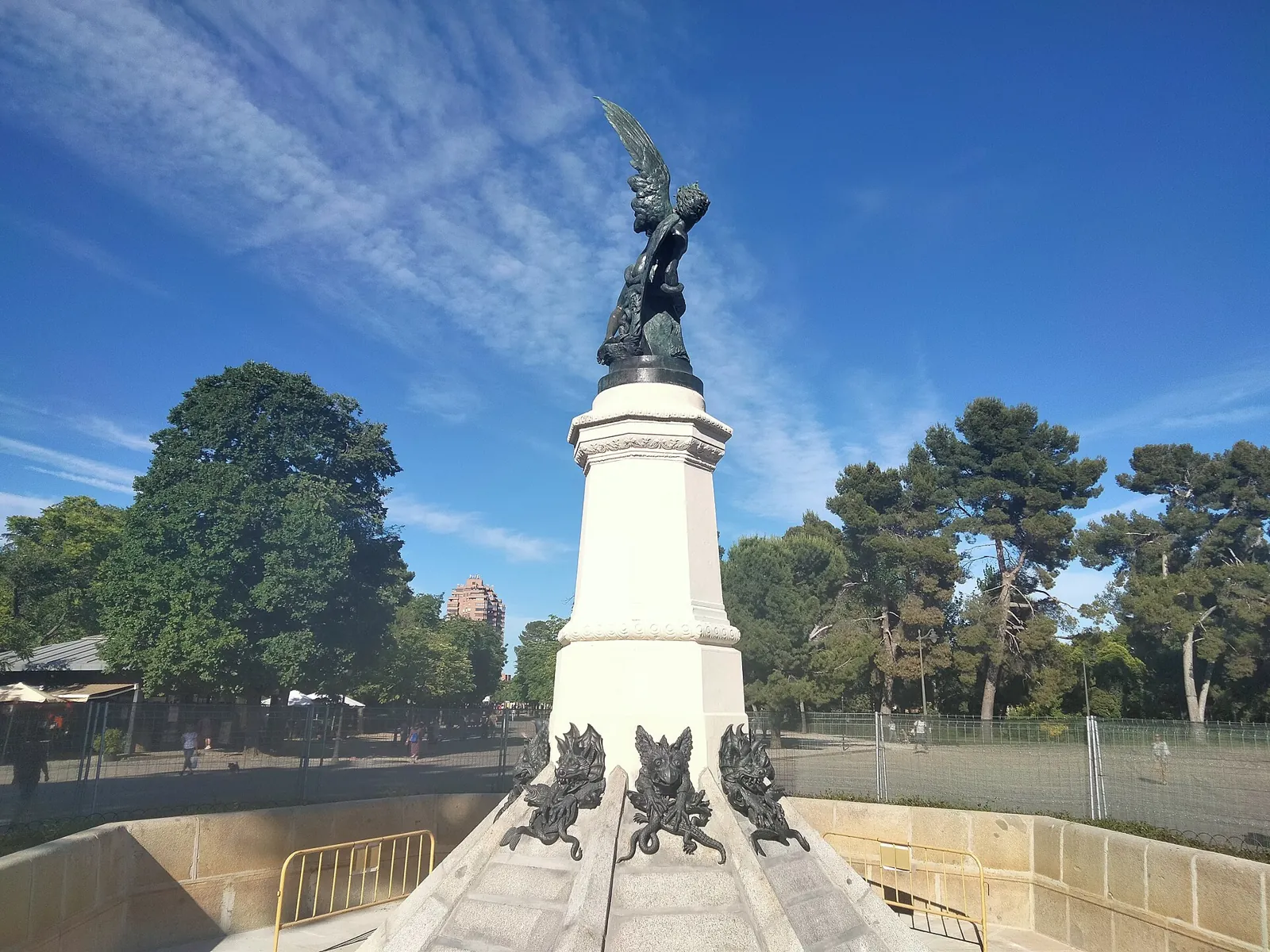 The Fallen Angel fountain in Retiro Park: a bronze angel being cast out of Paradise on a white pedestal, with bronze demon figures at the base