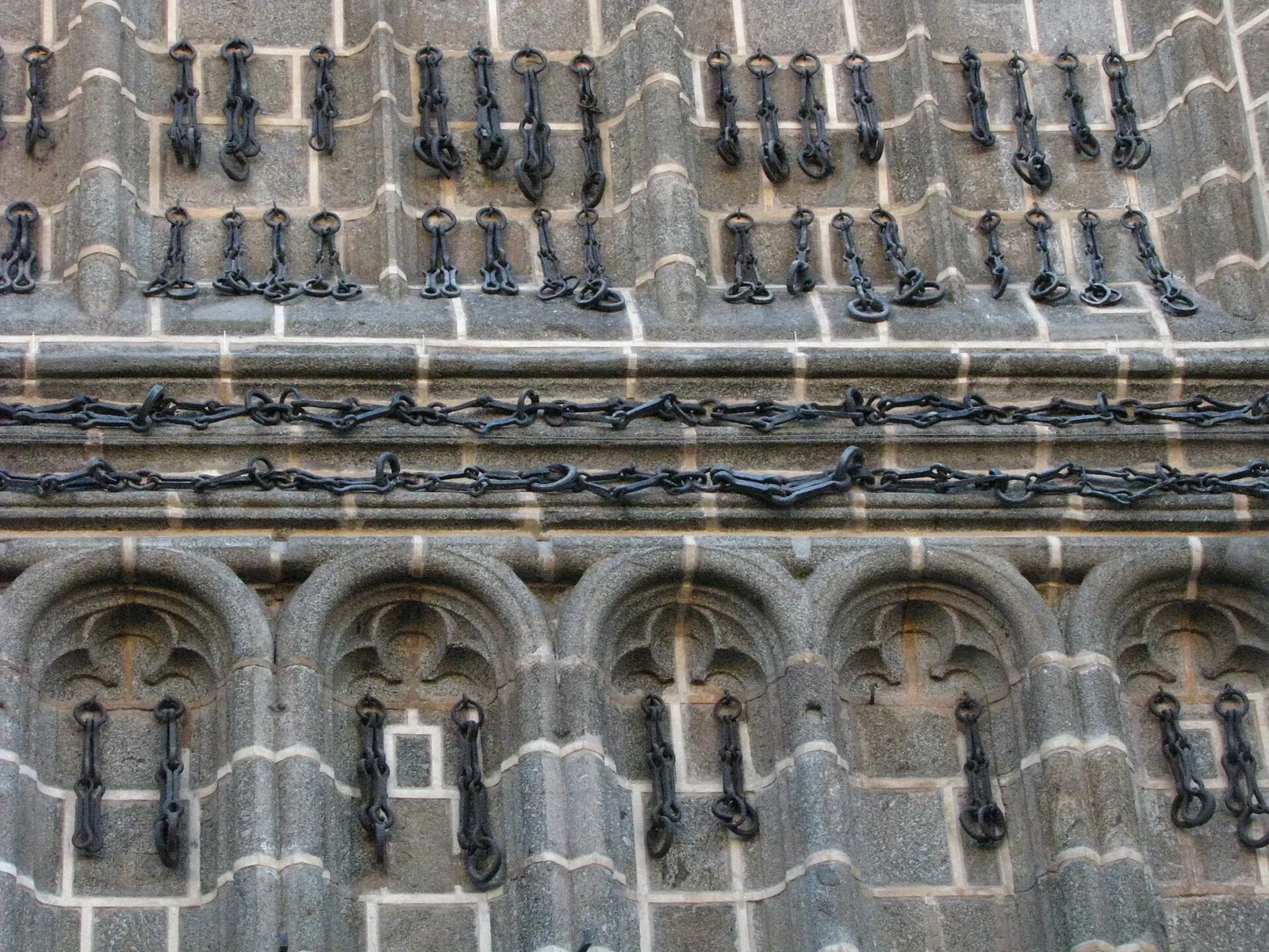 The iron chains hanging on the granite wall of the church of San Juan de los Reyes, in horizontal and vertical rows