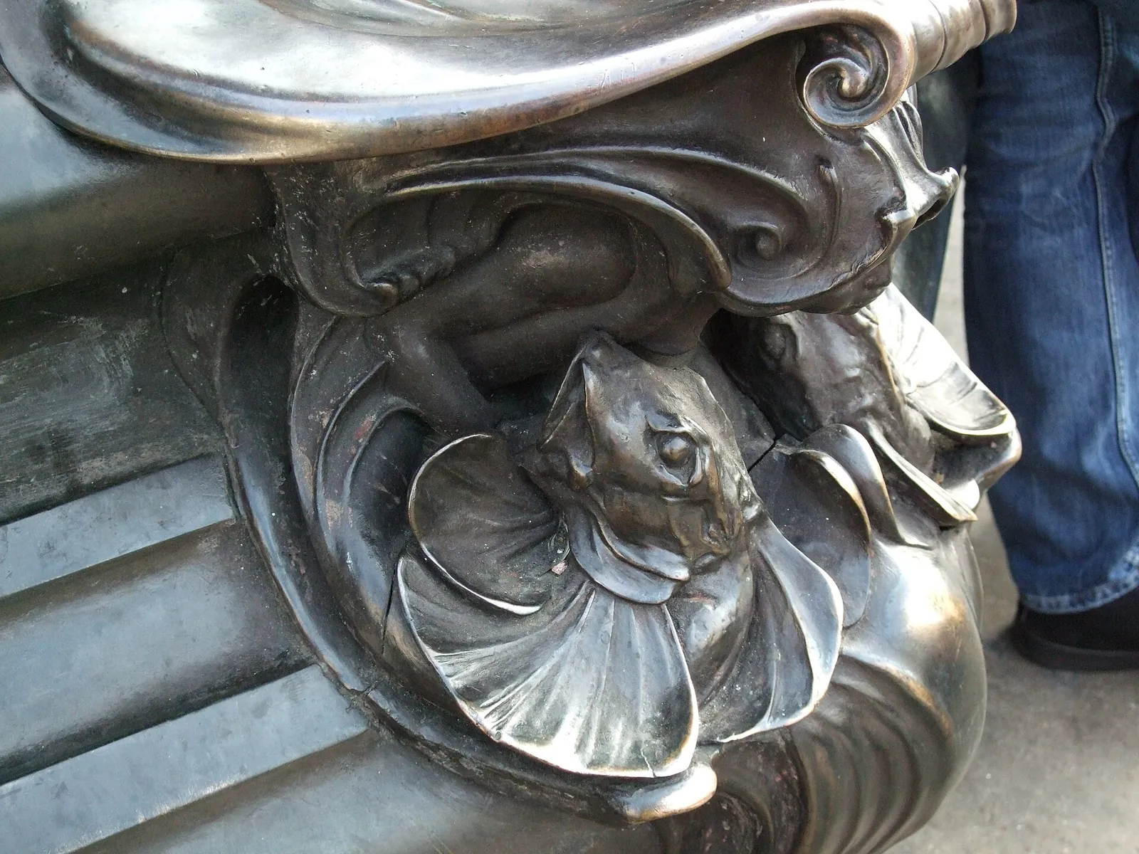 Bronze detail at the base of the fountain: a sea creature on a shell, among scrolls