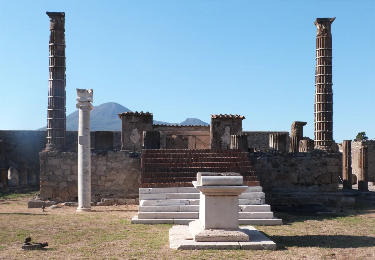 The Temple of Apollo in Pompeii: the podium and its steps, the white marble altar, the Ionic sundial column and Mount Vesuvius behind