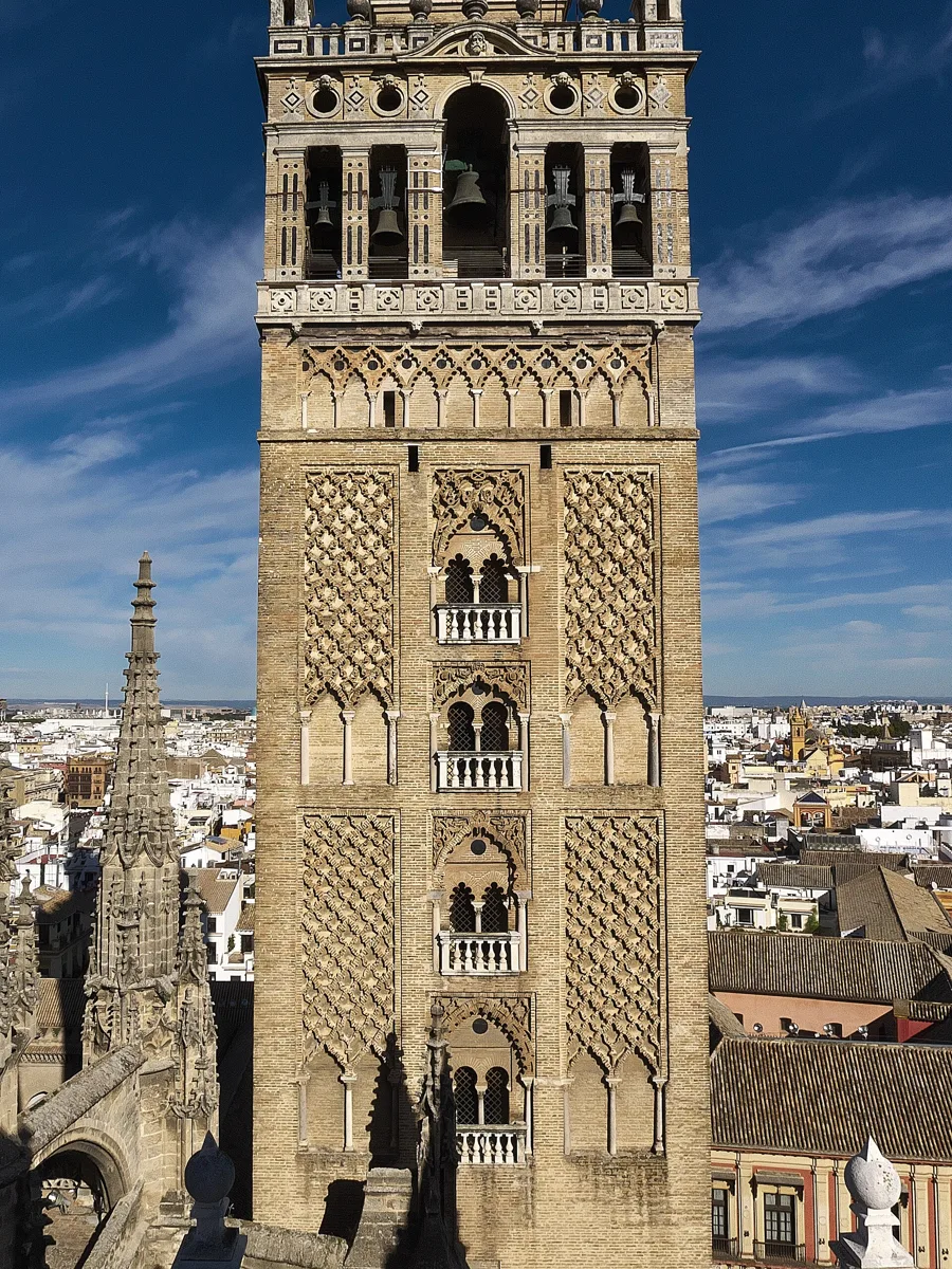 The south face of the Giralda in Seville: the Almohad brick minaret with its diamond-pattern panels and paired windows, topped by the Renaissance belfry