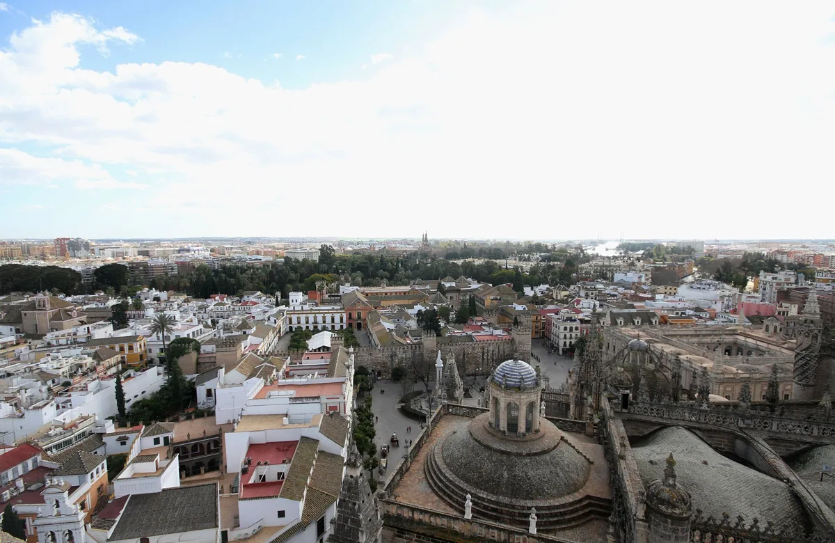 View from the Giralda over the rooftops of Seville towards the Real Alcazar, with a dome of the cathedral roof in the foreground
