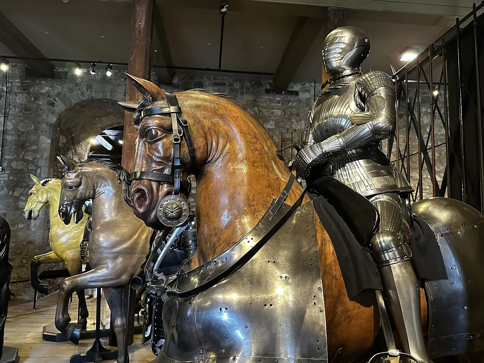 Carved wooden horses, the front one in armour and ridden by a figure in full plate armour, in the Line of Kings display inside the White Tower