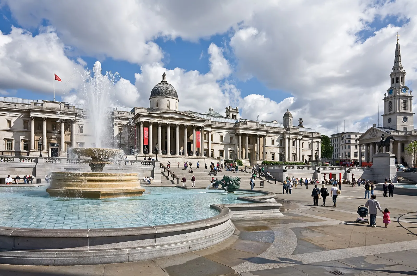 Trafalgar Square with one of its fountains in the foreground and, behind, the domed front of the National Gallery and the spire of St Martin-in-the-Fields