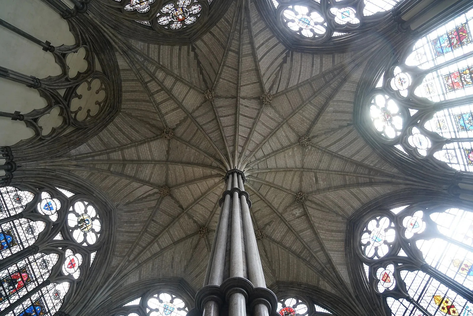 The vault of the Westminster Abbey Chapter House, its ribs fanning out from a slender central pillar between large stained-glass windows